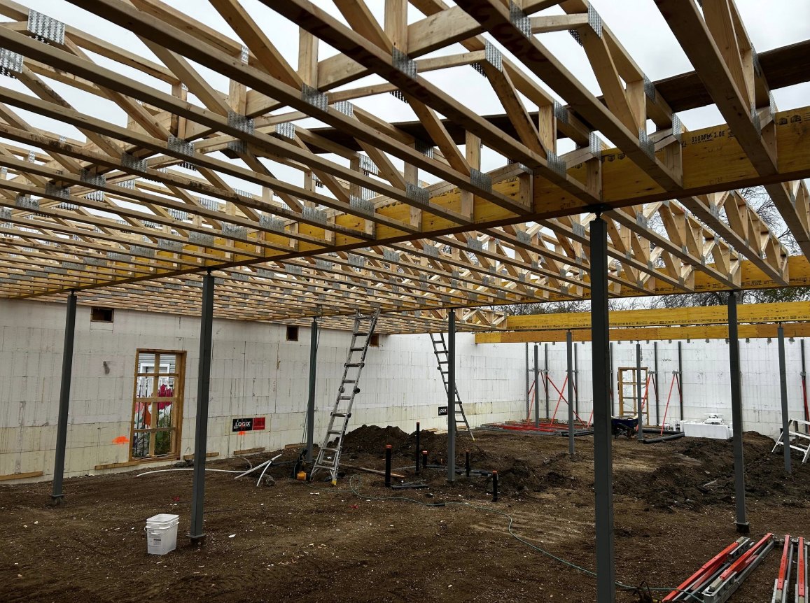 Interior of a commercial ICF building under construction, with roof trusses set on steel columns and ICF walls around the perimeter